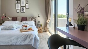 A bedroom with a bed, a bedside table with a lamp, a window with curtains, and framed pictures on the wall. - Beautiful private villa for 8 guests with hot tub, private pool, WIFI, A/C, TV and terrace (Umag)