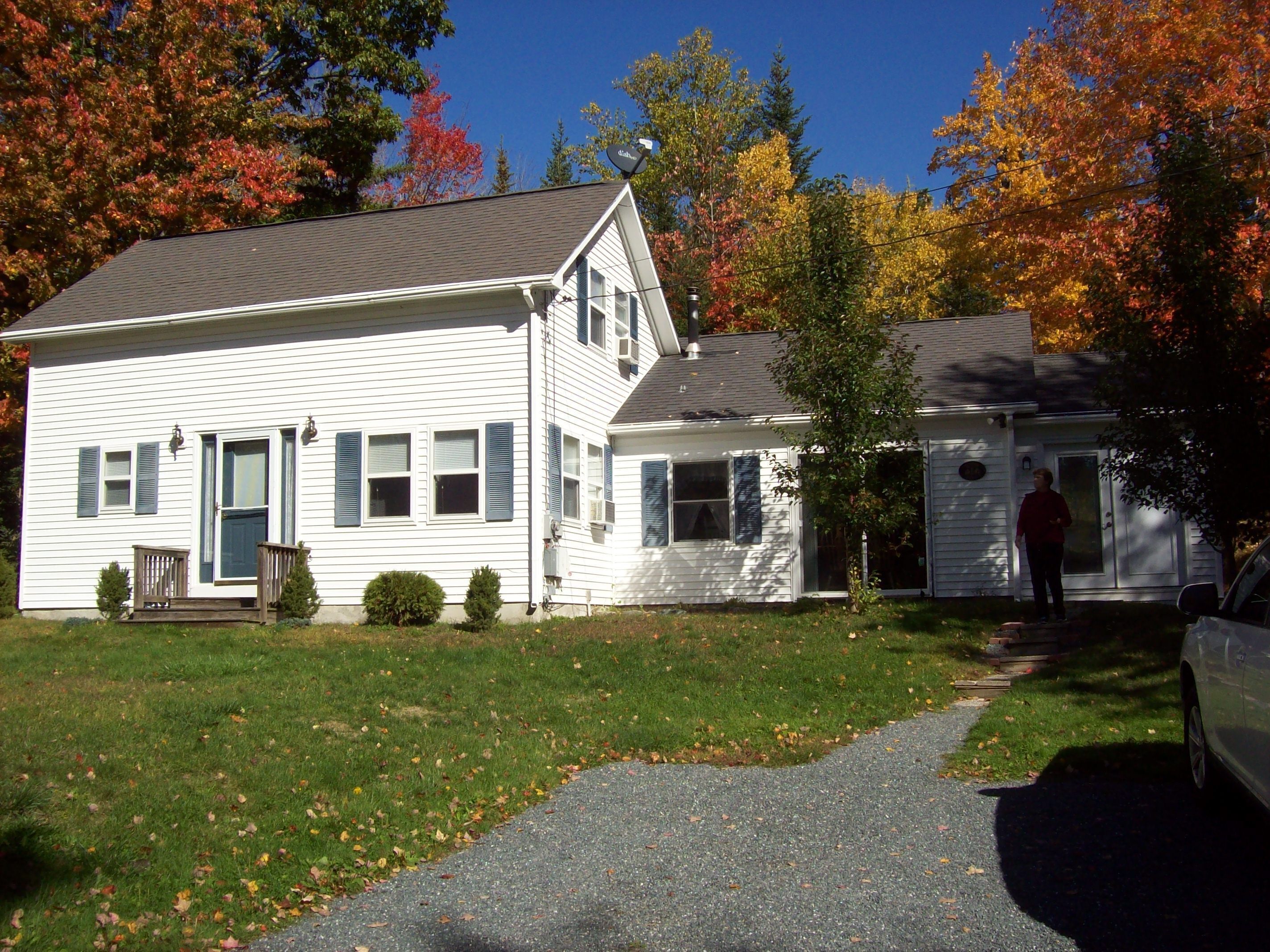 A two-story white house with a front porch and a garage.
