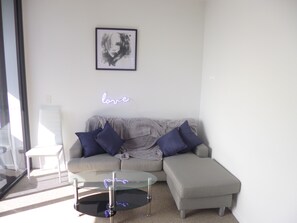 Relax in this stylish living room with a grey sofa, coffee table, and artwork above.