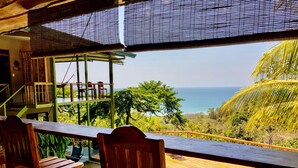 Eine Holzterrasse mit Pool mit Blick auf Strand und Meer.