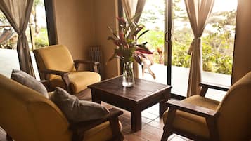 Um quarto com uma mesa de centro de madeira, duas poltronas amarelas e um vaso de planta.