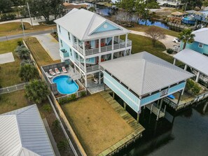 Une maison à deux étages dotée d’une grande terrasse et d’une piscine.