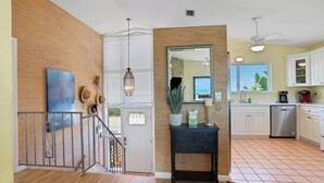 A modern kitchen with white cabinets, a black countertop, and a ceiling fan. - Welcome to Villa Rosa! A 4 Bedroom 3 Bath Oceanfront Getaway (St. Augustine)