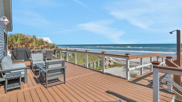 A wooden deck with outdoor furniture, a railing, and a view of the ocean. - Welcome to Villa Rosa! A 4 Bedroom 3 Bath Oceanfront Getaway (St. Augustine)