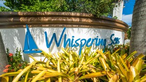 A sign with the name "Whispering Sands" surrounded by tropical plants. - Whispering Seas (Tower Isle)