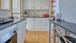 A modern kitchen with white cabinets, a black countertop, and a red toaster. - Cosy apartment for 4 people with pool, A/C, WIFI, TV and terrace (Benissa)