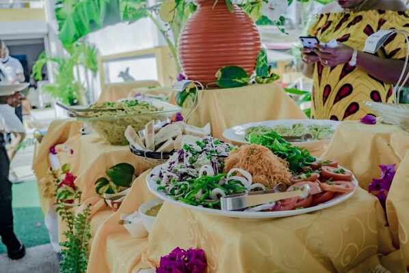A buffet table with various dishes, a large vase, and a name tag holder.