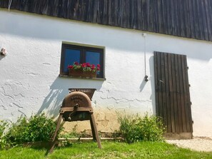 Ein weißes Gebäude mit einem Fenster, einer Holztür und einem Metallfass mit der Nummer 520.