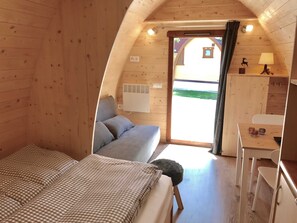 Een gezellig houten kamer met een bed, een klein bureau en een raam.