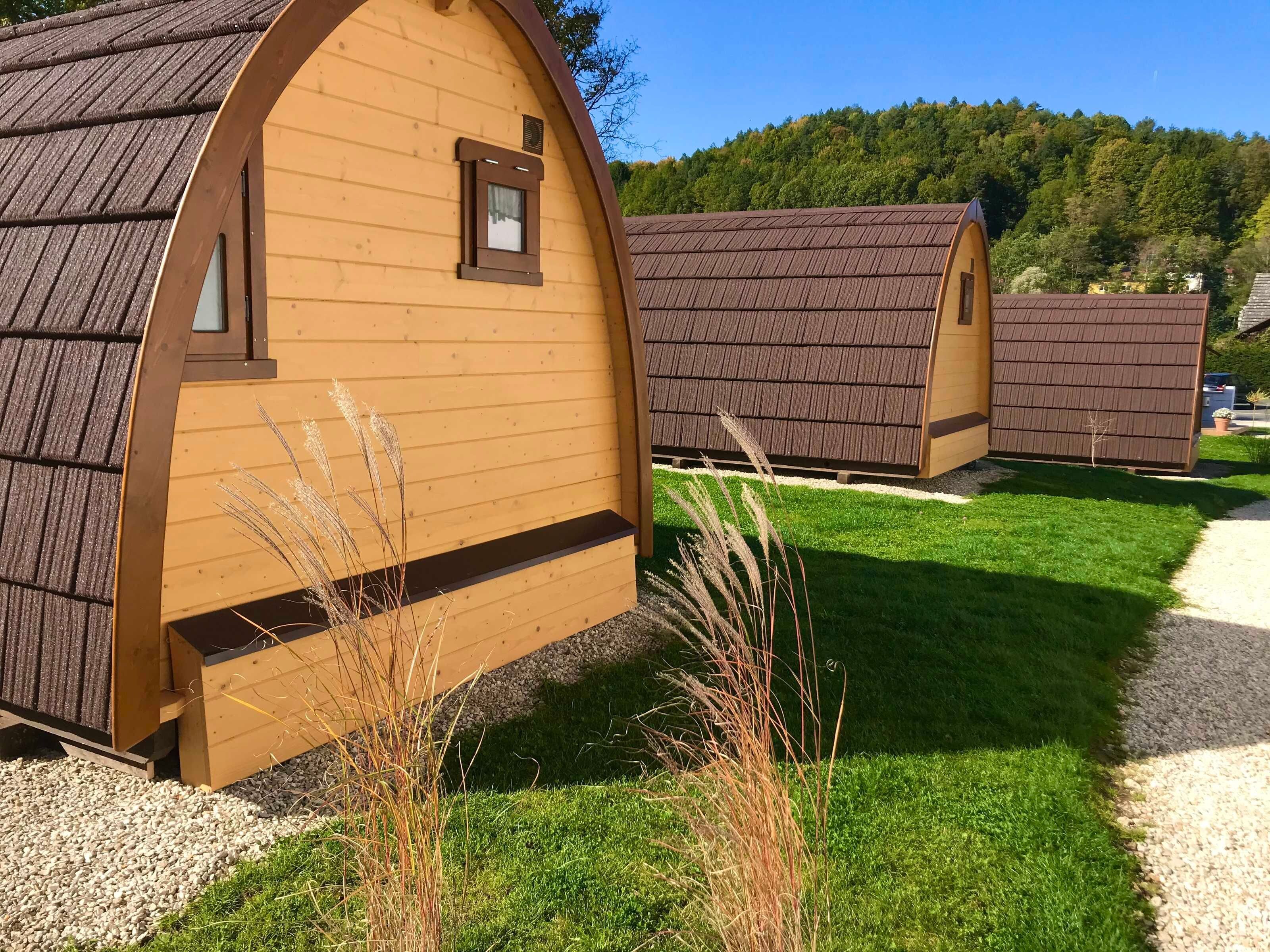 Une rangée de cabanes en bois, dotées de toits à deux versants, chacune ayant une petite fenêtre et une porte.