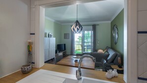 A modern living room with a grey sofa, a wooden coffee table, and a TV on a stand. - Playa Grande - Punta del Moral Beach PPHG67P42 (Punta del Moral)