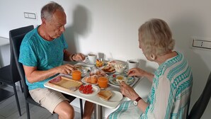 Due persone sedute a tavola con diversi cibi e bevande.