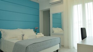Una camera da letto moderna con un letto, una scrivania e uno specchio.