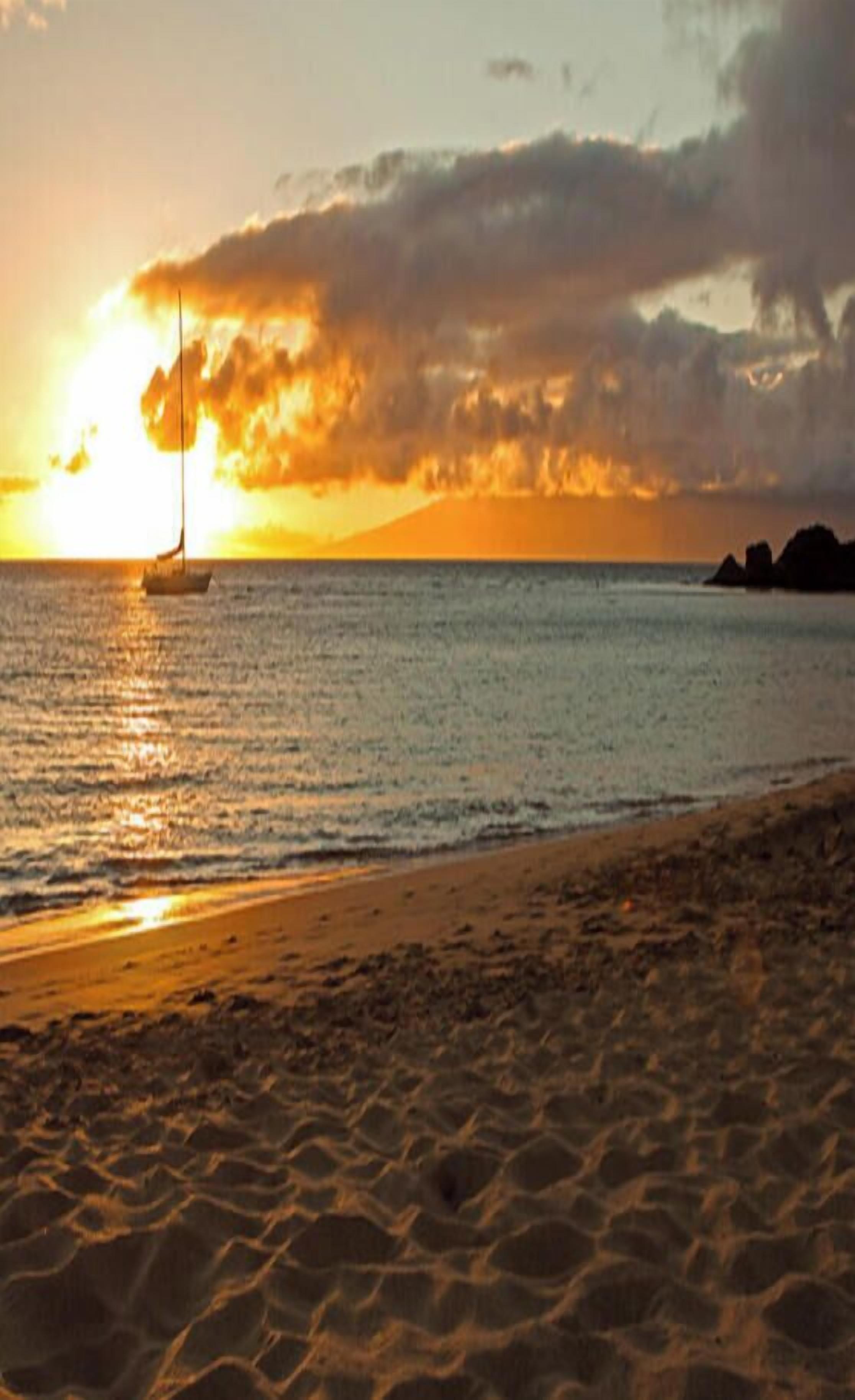 Une plage au coucher du soleil, avec un ciel dégagé et une mer calme.