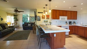 Una cocina moderna con una isla central, armarios de madera y un microondas.