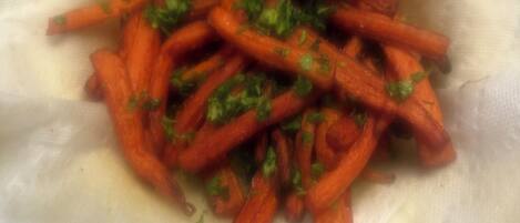 Gros plan d’un plat contenant des carottes coupées en julienne et des herbes hachées.