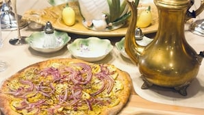 A table with a pizza, a decorative swan, a brass pitcher, and a floral-patterned plate. - Destination getaway! B&B Italian Manor. Italian cooking classes. “Organic” (Ruston)