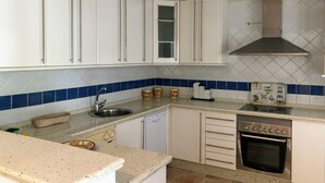 A kitchen with white cabinets, a stainless steel sink, a dishwasher, and a built-in oven. - Chalet La Costa, close to the beach and with Wifi (Chiclana de la Frontera)