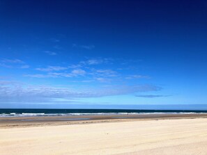 A beach with a clear sky and ocean.