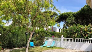 A garden with a stone pathway, a white fence, and blue chairs. - Chalet La Costa, close to the beach and with Wifi (Chiclana de la Frontera)