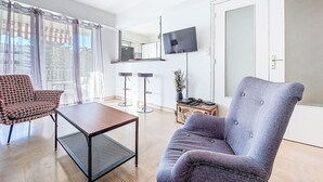 A modern living room with a sofa, a coffee table, and a TV mounted on the wall. - Le Clos tranquille by Interhome (Nice)