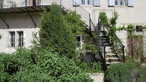 Een gebouw met een trap, een balkon en een tuin.