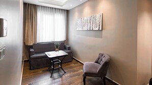 Una sala de estar moderna con sofá, sillón y mesa de centro.