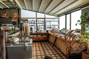 Una cocina con piso a cuadros, armarios de madera y diversos utensilios de cocina.