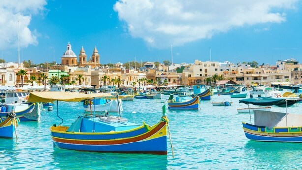 A marina with colorful boats and a historic building in the background. - Peaceful Penthouse with large Sunny Terrace (Marsaxlokk)