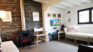 A cozy living room with a fireplace, a television, and a comfortable seating area. - Quinta dos Morangueiros, Douro Valley (Armamar)