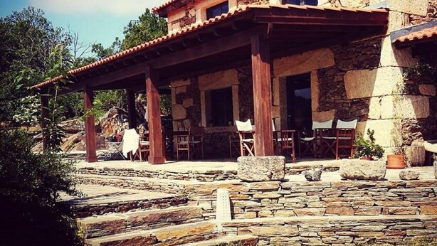 A stone building with a covered patio area, outdoor seating, and a stone pathway. - Quinta dos Morangueiros, Douro Valley (Armamar)
