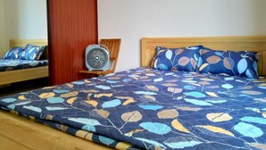 A bedroom with a bed, a wooden headboard, a mirror, and a fan. - Hidden from the noise (Tp. Vũng Tàu)