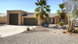 A modern two-story house with a garage, palm trees, and desert landscaping. - Poolside Panorama- Perfect Lake view (Lake Havasu City)