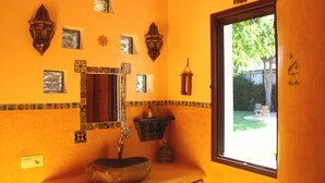 A bathroom with a large window, a stone sink, and decorative wall tiles. - Comfortable apartment and swimming pool in the shade of the pine forest of Chipiona (Chipiona)