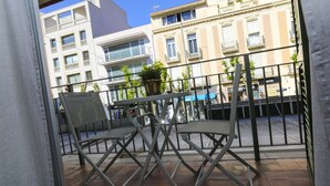 Een balkon met twee stoelen en een bloempot.