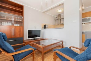 Un salon moderne avec un téléviseur, des meubles en bois et une table en verre.
