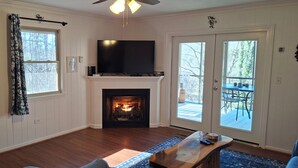 Una sala de estar con chimenea, televisor de pantalla plana y comedor.