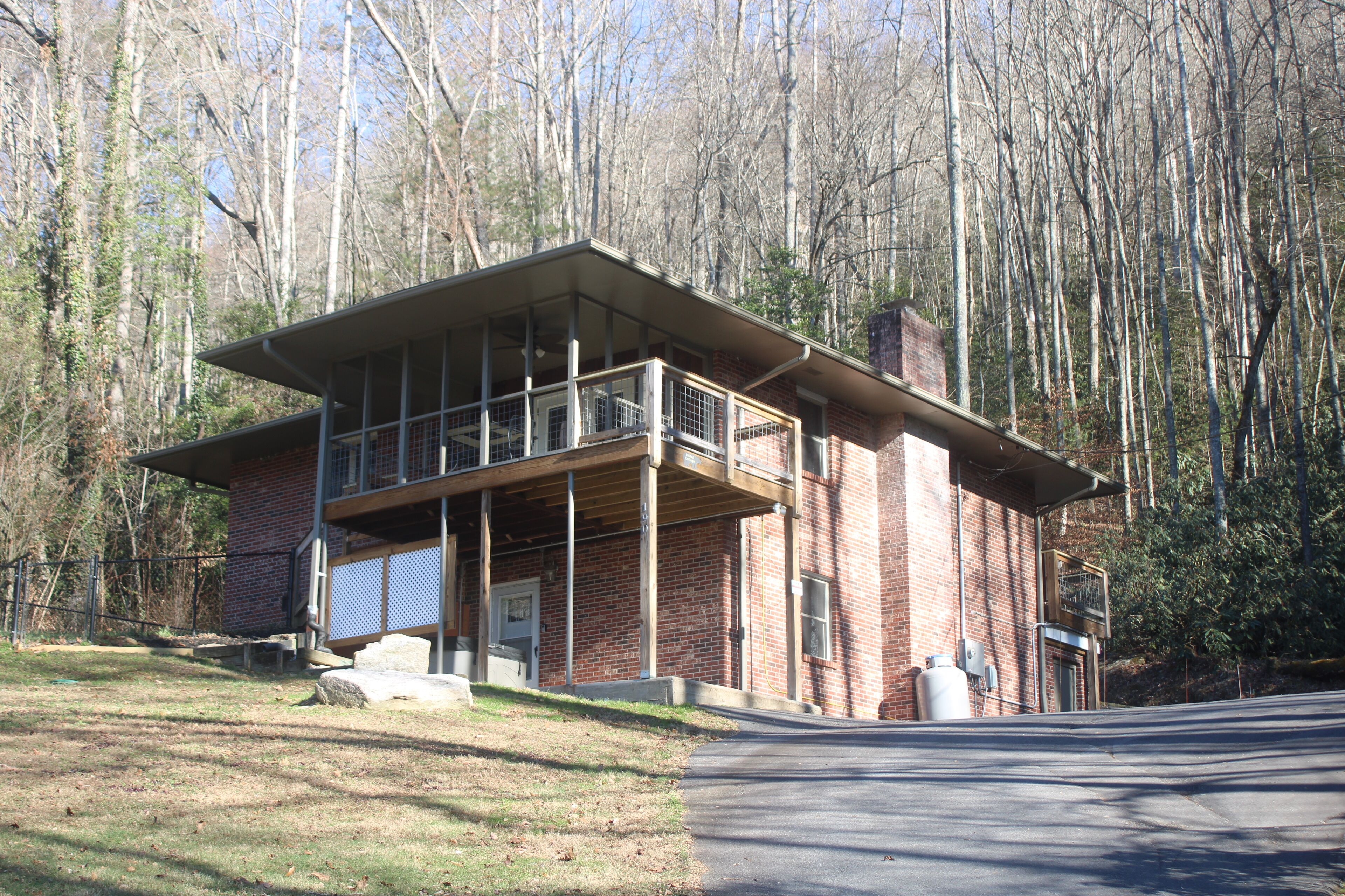 Un bâtiment à deux étages, doté d’un toit plat et de grandes fenêtres, entouré d’arbres.