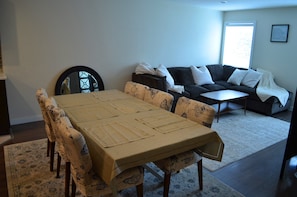 Cozy living and dining area with a comfortable sofa, dining table, and patterned rug.