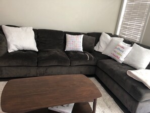 Relax in this stylish living room with a comfortable dark grey sofa and vibrant pillows.