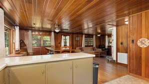 Een houten interieur met een keuken, een eethoek en een zithoek.
