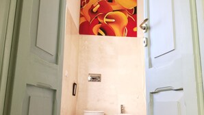 A bathroom with two toilets, a sink, and a toilet brush. - Beachfront apartment with garden (Grottammare)