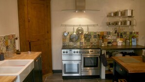 Een keuken met een dubbele oven, een houten kast en een betegelde spatwand.