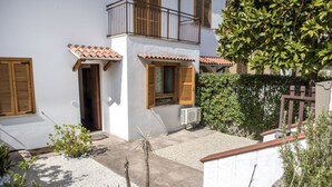 A two-story building with a white facade, wooden shutters, and a tiled roof. - N175 - Numana, two-room apartment with porch (Numana)