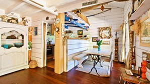 A cozy, rustic room with a wooden staircase, a dining table with chairs, and a bench. - Second line: pretty hut in the 44 Hectares (Lège-Cap-Ferret)