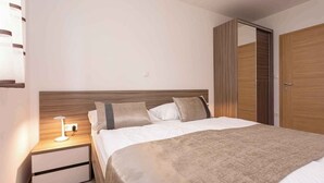 Un dormitorio con cama, mesita de noche, lámpara y armario.