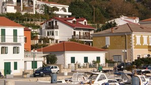 A coastal town with buildings featuring balconies and red-tiled roofs.