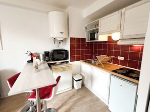 A compact kitchen with a microwave, toaster, and sink. - Le Havre du Port - T2, quiet, sleeps 4, near Port (Cancale)