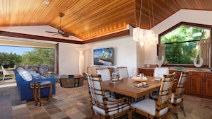 A spacious living area with a wooden ceiling, a dining table with chairs, a sofa, and a television. - Private Villa, Golf Course Front with a Private Pool and Spa! (Kamuela)
