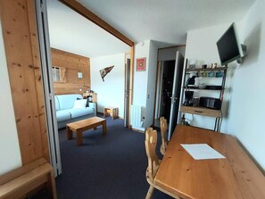 Cozy living space with a dining table, sofa, and bench, perfect for relaxing and socializing.